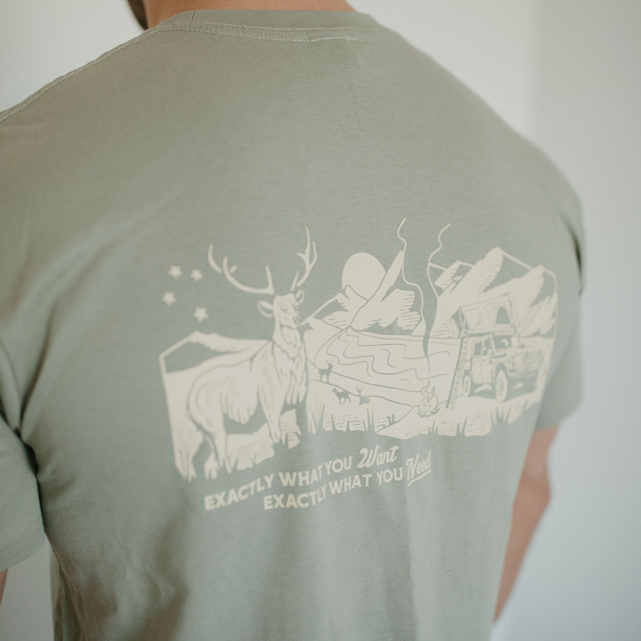 Green t-shirt with a graphic design on the back, featuring a deer and text.