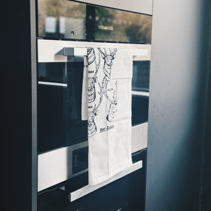 Towel with a design hanging on the handle in front of a oven.