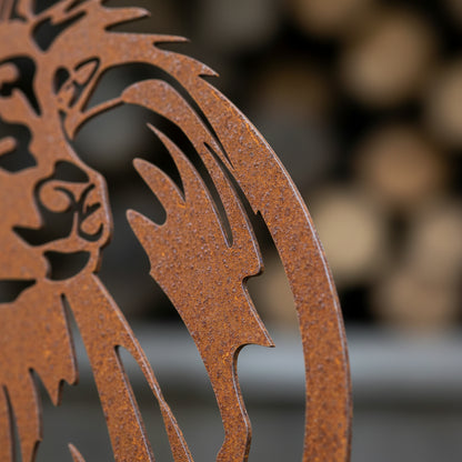 Rust-colored metal decorative element with intricate design against a blurred background
