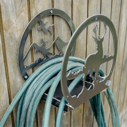 Metal hose holder with nature-themed design on a wooden background