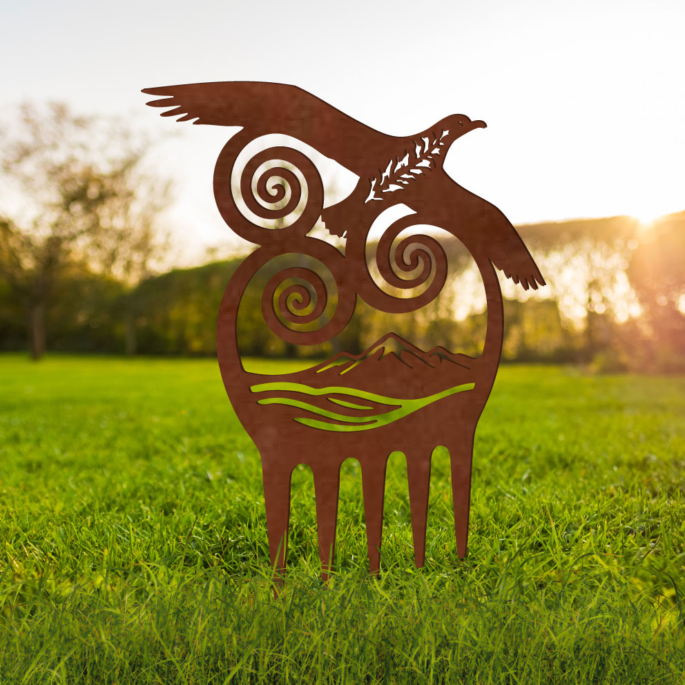 Decorative metal sculpture of a bird with spiral designs on grass