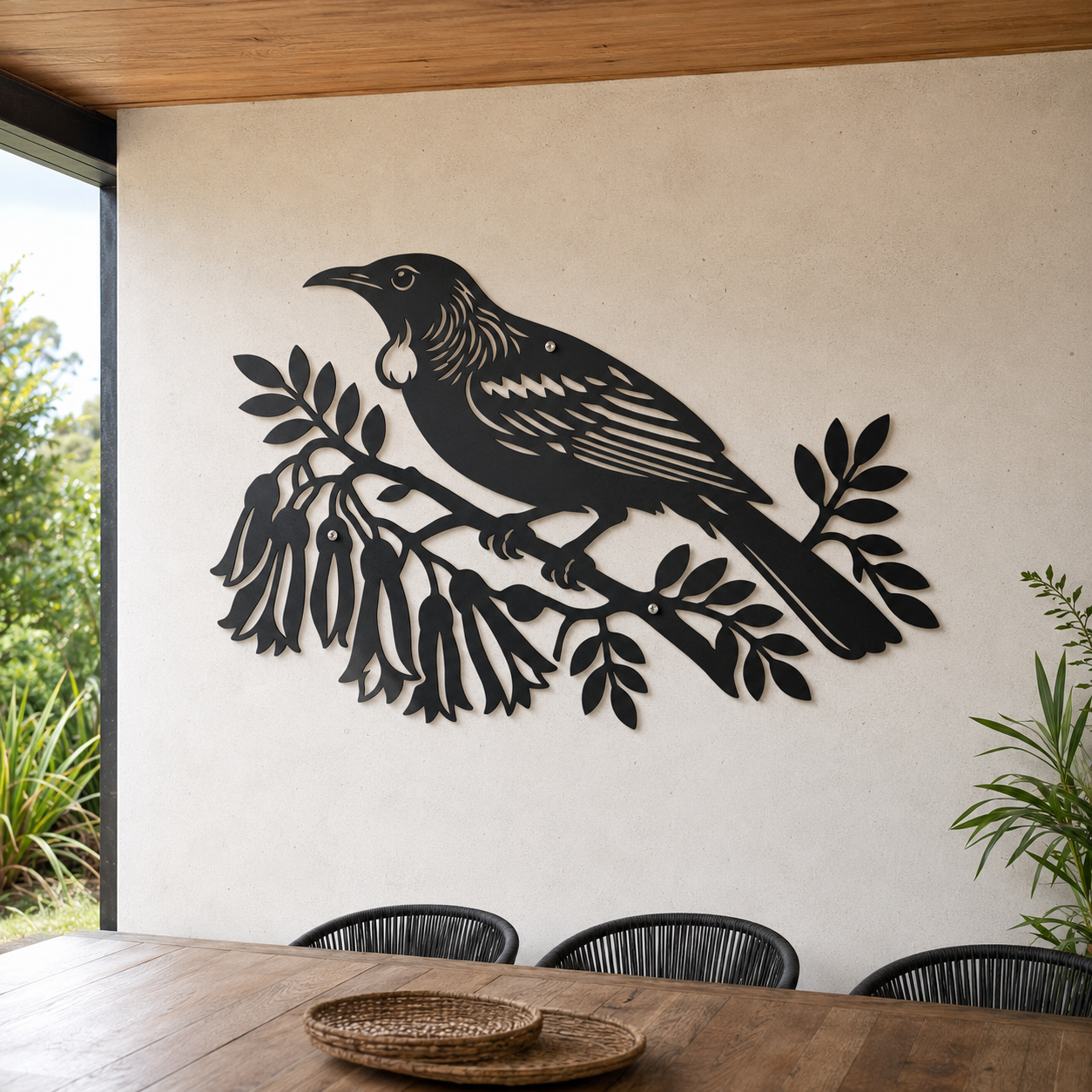 Powder-coated black Tui Bird wall art in a garden setting